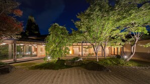 A modern building with a glass facade, surrounded by landscaped gardens and trees. - Surikamitei Ohtori (Fukushima)