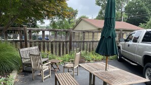 Une terrasse extérieure avec des meubles en bois et un parasol vert.