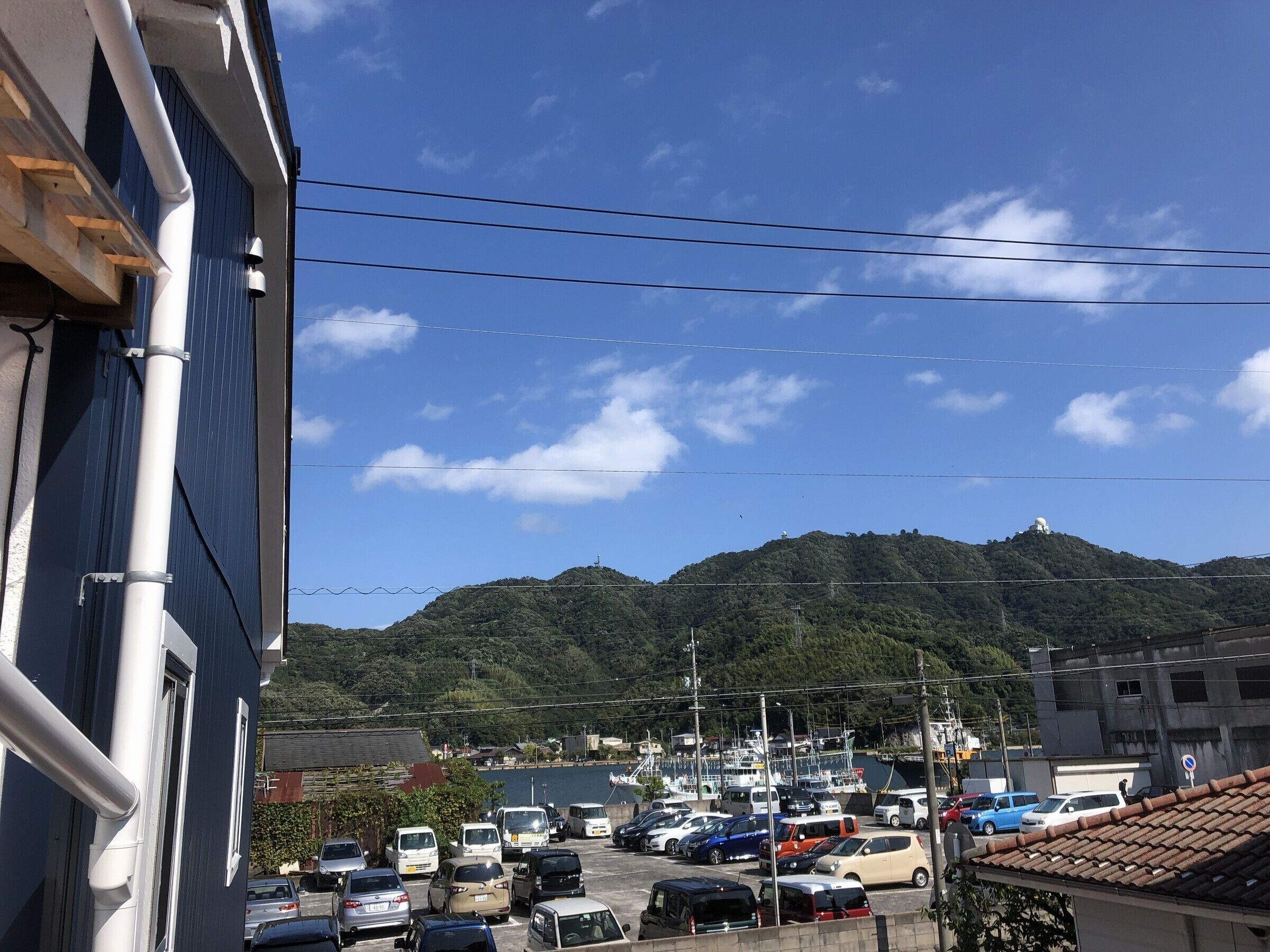 A parking lot with various cars and a mountain in the background.