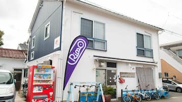 Un bâtiment à deux étages, avec un distributeur automatique, des vélos et une enseigne indiquant un restaurant.