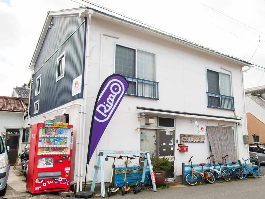 Un bâtiment à deux étages, avec un distributeur automatique, des vélos et une enseigne indiquant un restaurant.