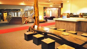 A modern lobby with a wooden reception desk, a staircase, and a red carpet leading to the upper floor. - Hotel Ryusendo Aizan (Iwaizumi)