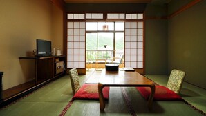 A traditional Japanese room with tatami flooring, a low table, and shoji screens. - Hotel Ryusendo Aizan (Iwaizumi)