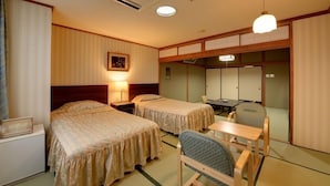 Une chambre d’hôtel avec deux lits, un bureau, une chaise, une lampe et un tableau au mur.