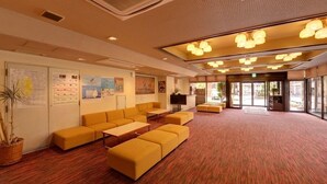 Un hall d’entrée avec un espace salon, un téléviseur et un comptoir d’accueil.