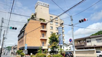 A multi-story building with a parking sign, a no parking sign, and a traffic light.