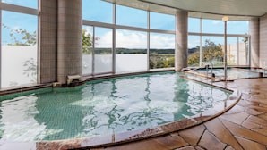 Piscina interior con amplias vistas del paisaje circundante a través de grandes ventanales.