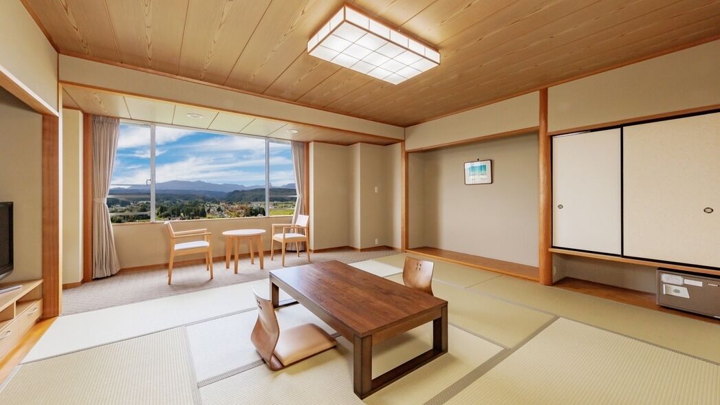 Una habitación japonesa tradicional con suelo de tatami, una mesa de madera baja y un televisor.