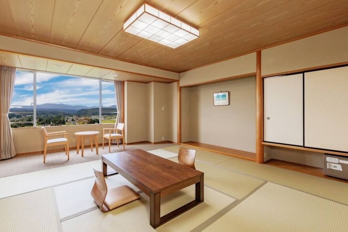 Una habitación japonesa tradicional con suelo de tatami, una mesa de madera baja y un televisor.