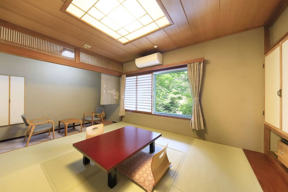 Ein traditioneller japanischer Raum mit Tatami-Boden, einem niedrigen Tisch und Schiebetüren.