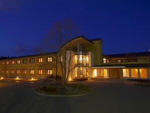 A hotel with multiple buildings, a central structure with large windows, and a well-lit entrance. - Hotel Folkloro Hanamakitowa (Hanamaki)