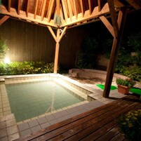 A wooden deck with a swimming pool, surrounded by a wooden fence and greenery.