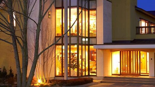 A modern two-story house with large windows and a well-lit entrance. - Hotel Folkloro Hanamaki Towa (Hanamaki)
