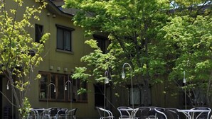 A building with outdoor seating and trees. - Hotel Folkloro Hanamaki Towa (Hanamaki)