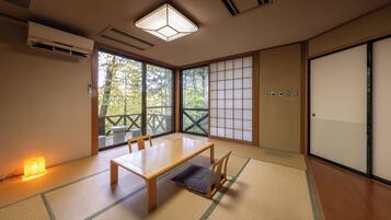 A traditional Japanese room with tatami flooring, a low table, and sliding doors.