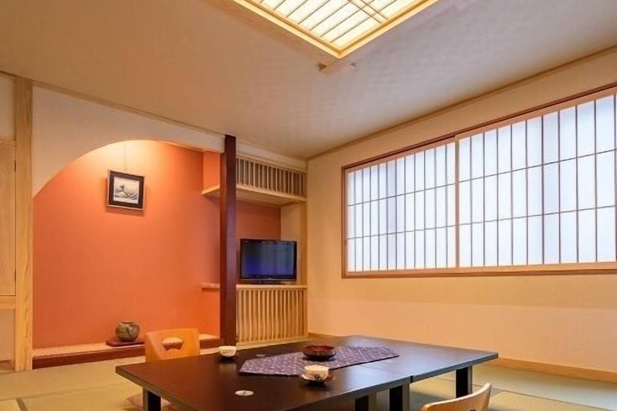A traditional Japanese room with tatami flooring, a low table, and sliding doors.