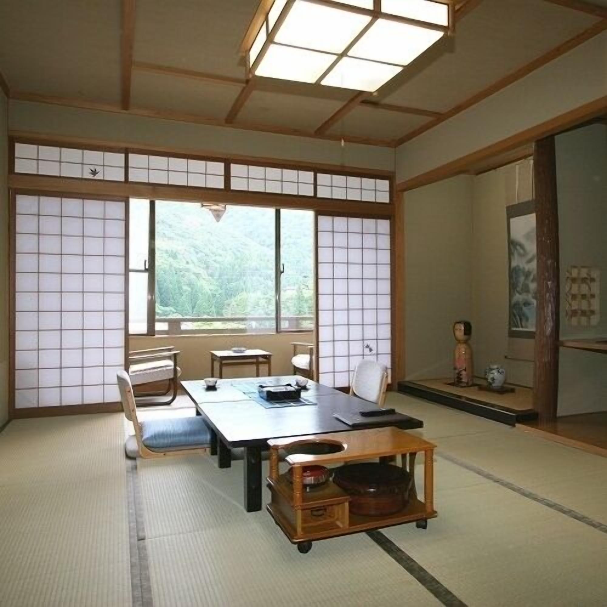 A traditional Japanese room with tatami flooring, a low table, and sliding doors.