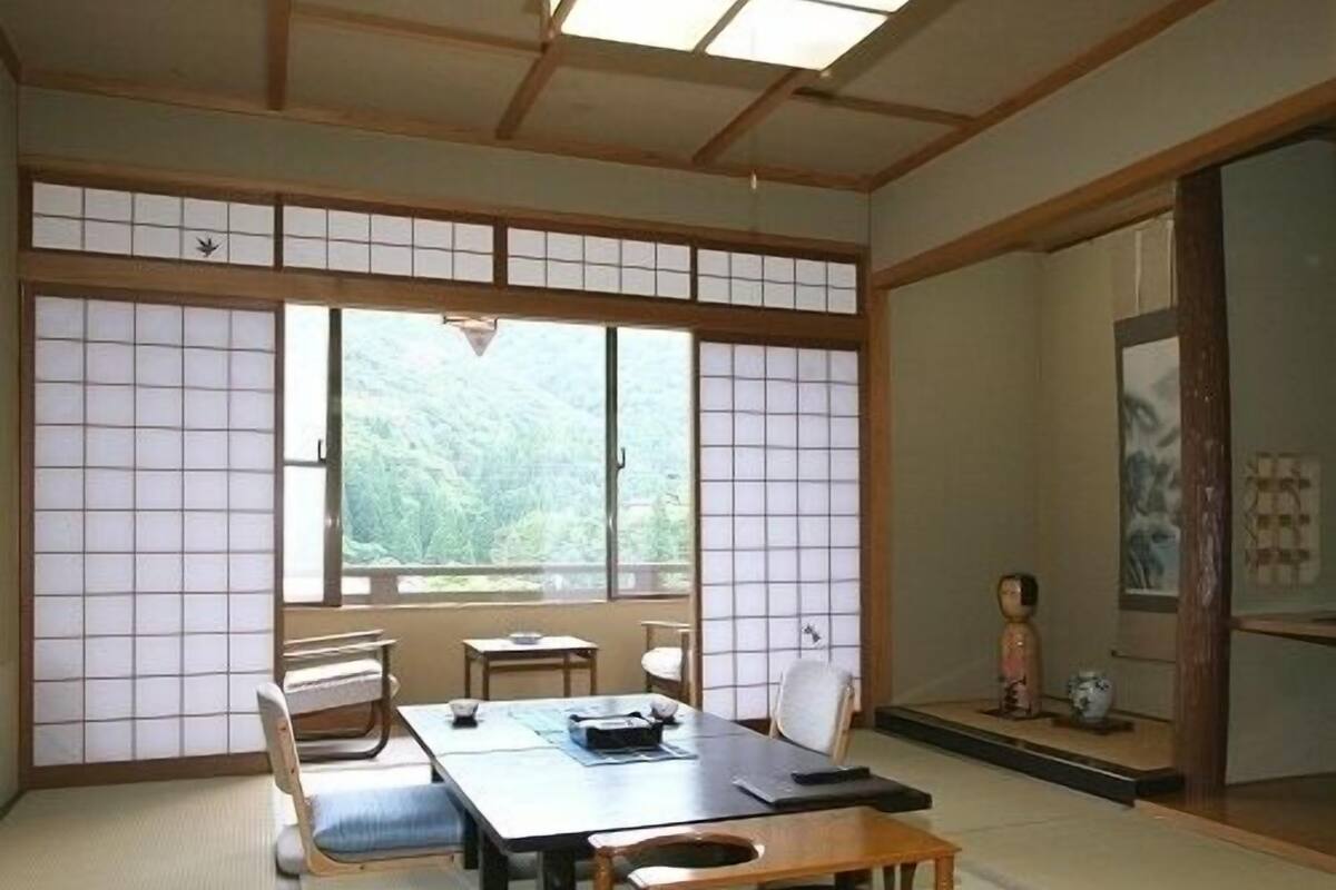 A traditional Japanese room with tatami flooring, a low table, and sliding doors.