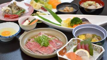 A variety of dishes including sashimi, vegetables, and a bowl of soup.