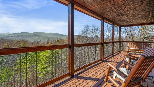 A wooden deck with a view of mountains and trees. - Mountain Views & FREE Attraction Tickets (Gatlinburg)
