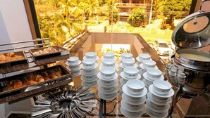 Un buffet de petit-déjeuner proposant divers aliments, avec des bols blancs portant l’inscription « AYOWA », disposés sur une table.