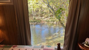 Un dormitorio con vista a un estanque y árboles.