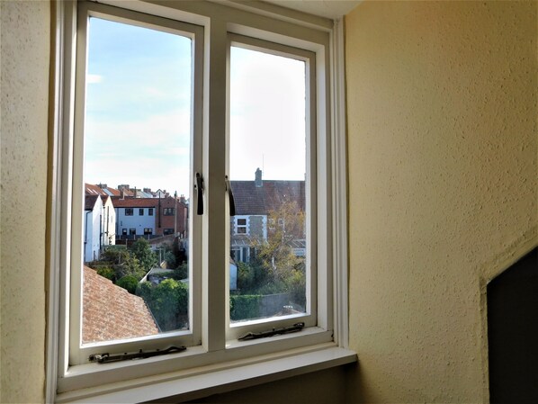 A window with a view of neighboring houses and a garden. - The Prairie - a deceptively spacious cottage with parking close to the beach in Sheringham (Sheringham)