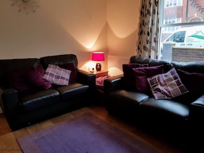 Relax in this inviting living room with two comfortable sofas, a side table, and a stunning city view.
