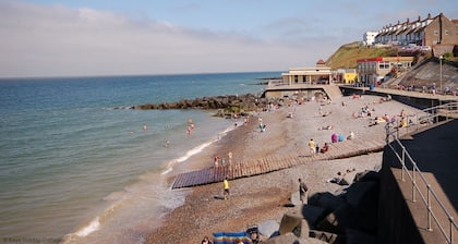 Hiljaisella kadulla tämä kaunis bungalow sijaitsee lähellä rantaa ja Sheringhamin kaupungin keskustaa