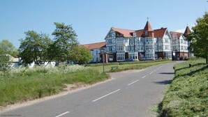 Ein traditionelles Hotel im Tudor-Stil mit auffälligem rotem Dach und weißer Holzverschalung.