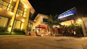 A hotel with a modern design, featuring a large entrance with a covered area and multiple balconies. - The White Elephant Home (Chiang Mai)