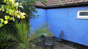 A blue-painted building with a window, a table, and chairs outside. - The Old Bake House - beautifully presented, ground-floor property just yards from the shops & cafes (Sheringham)