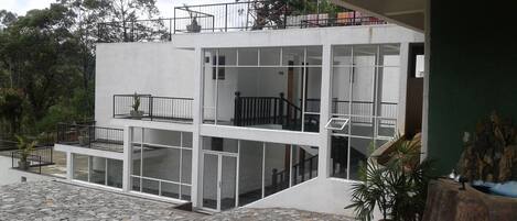 A modern multi-story building with balconies, large windows, and a stone-paved courtyard.