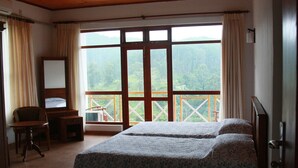 A bedroom with two beds, a wooden desk, a chair, and a large window with a balcony. - Hotel Alta Vista (Ella)