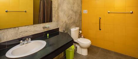 A bathroom with a sink, toilet, and handrails.