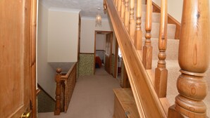 Eine Holztreppe mit Teppichboden, die zu einem Raum mit einer Tür führt.