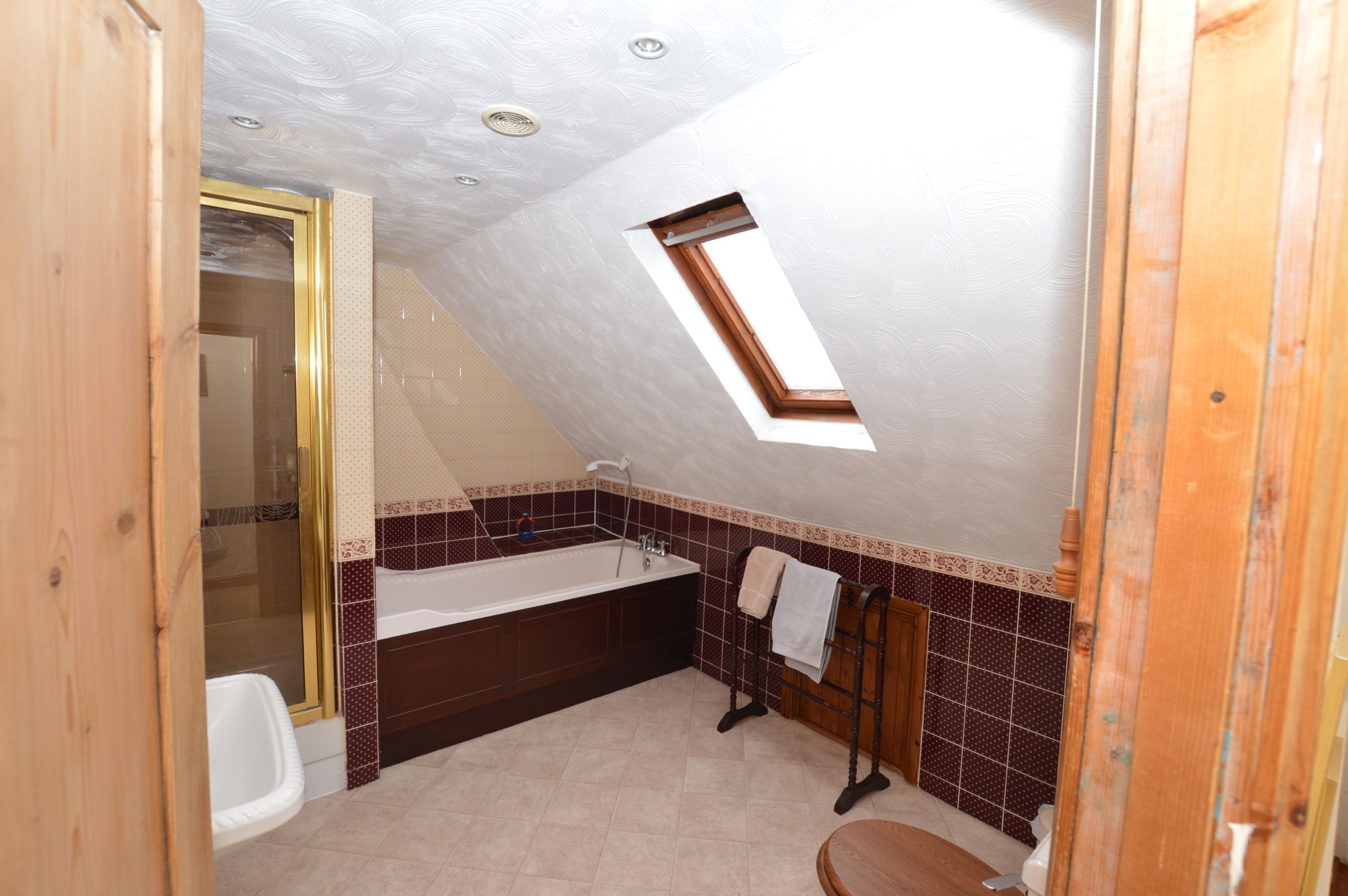 A small bathroom with a shower, a bathtub, and a toilet.