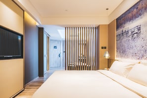 A modern hotel room with a large bed, a TV, a painting on the wall, and a wooden partition. - Atour Hotel Hongqiao Hub National Exhibition Center Shanghai (Shanghai)