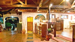 A cozy interior with a wooden ceiling, a reception desk, a mural, and a staircase leading to an upper level. - Oriental Sabang Hill Resort (Puerto Galera)