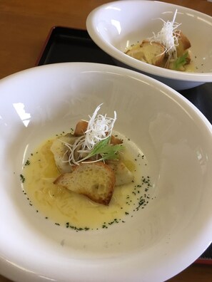 Two white bowls of food with bread and garnishes on a black tray. - Seaside Uwakai (Seiyo)