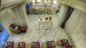 A spa area with multiple massage chairs, a central table with flowers, and a chandelier.