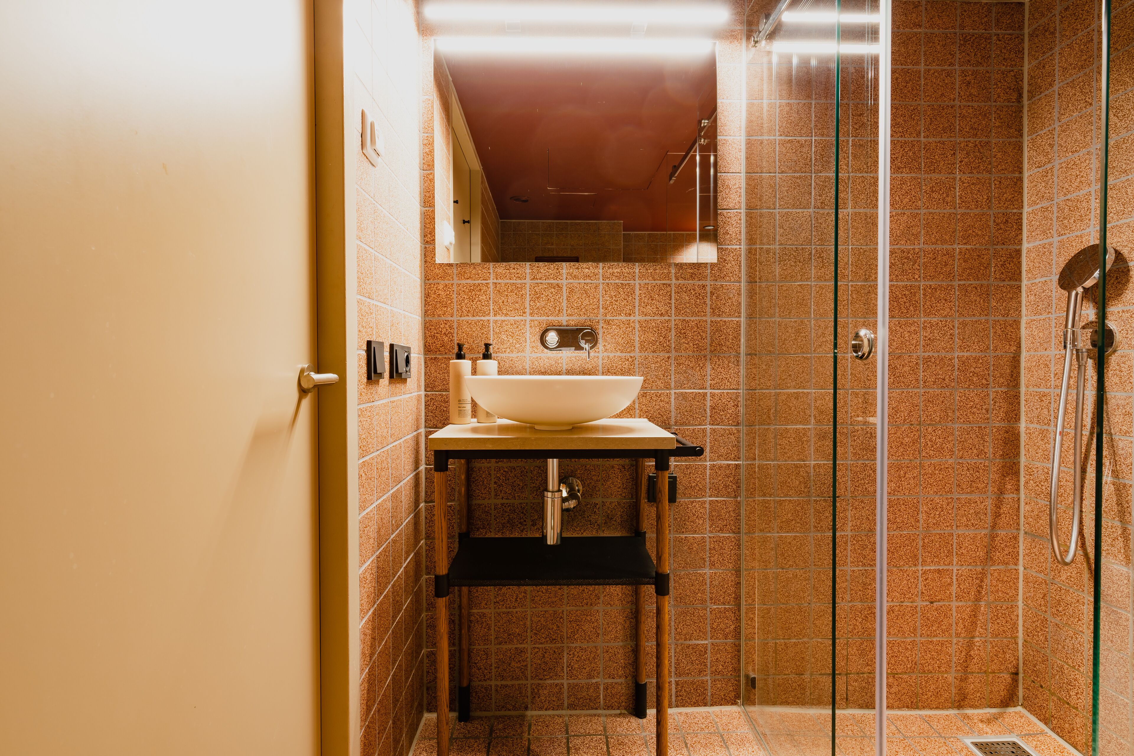 Un baño con lavamanos, espejo y ducha.