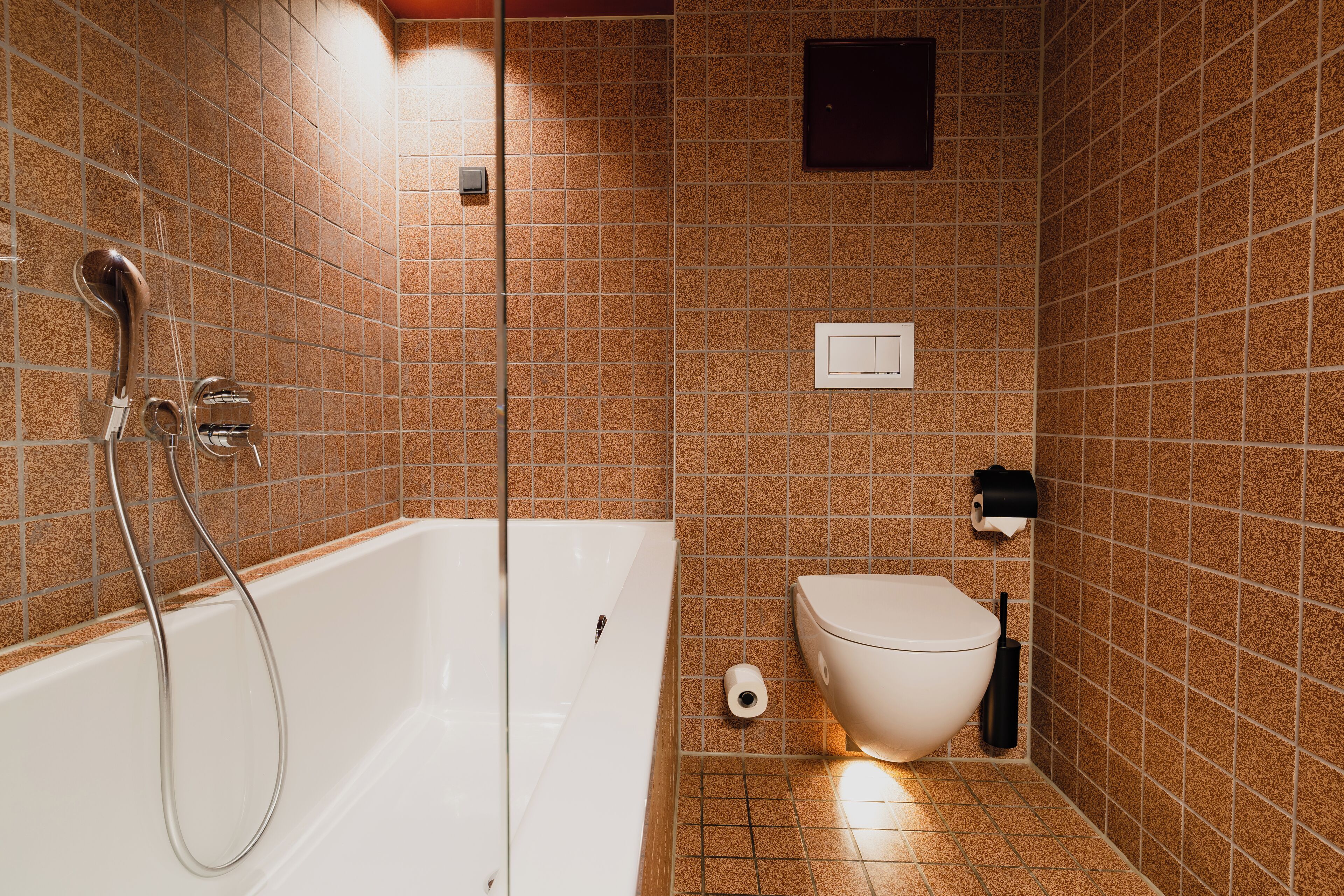 A bathroom with a bathtub, toilet, and shower.