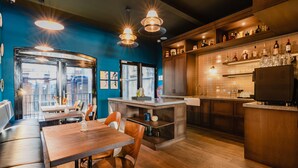Eine moderne Küche mit Holzschränken, einer integrierten Kochinsel und einer Bar mit Flaschen und Gläsern.