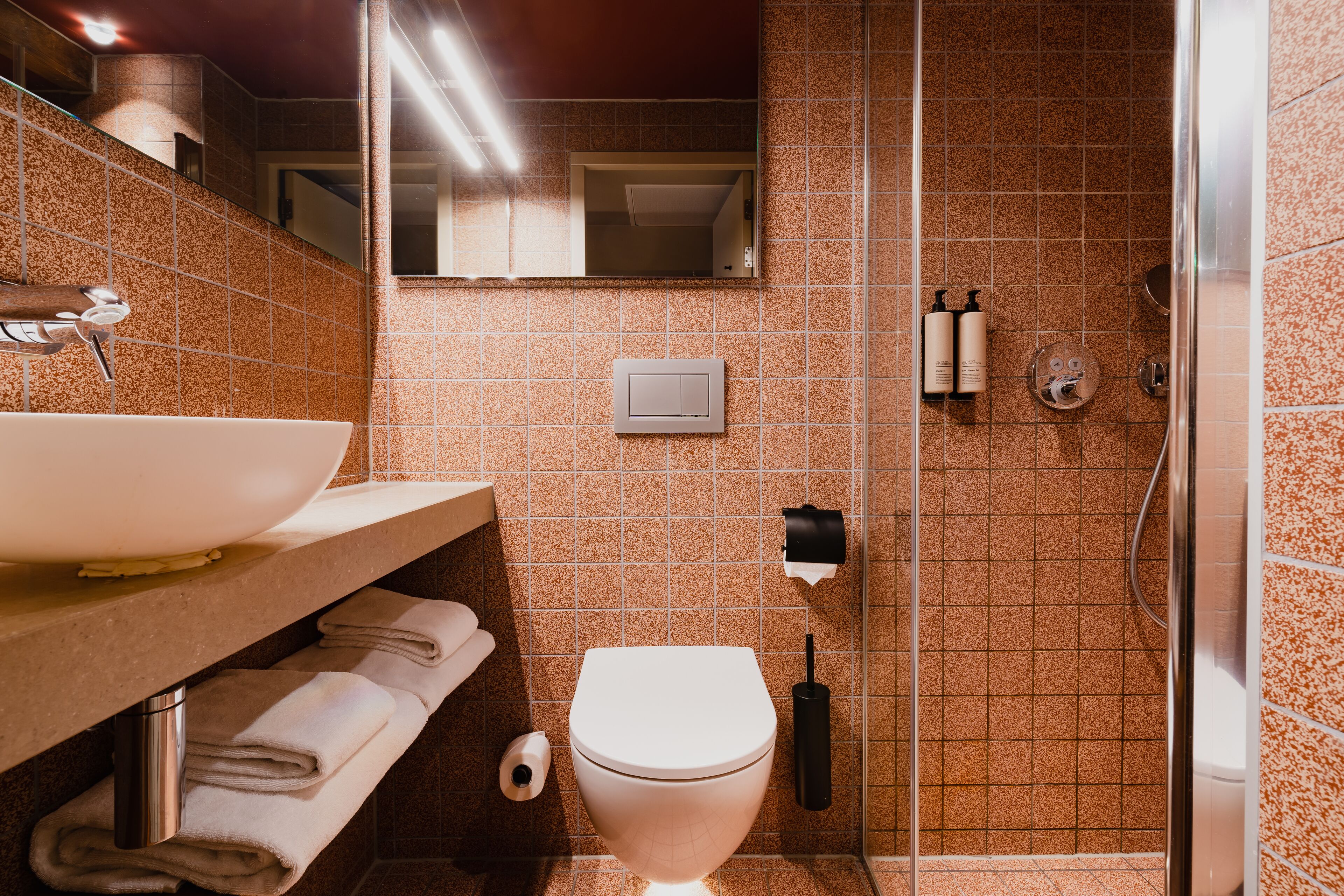 A bathroom with a sink, toilet, and shower.