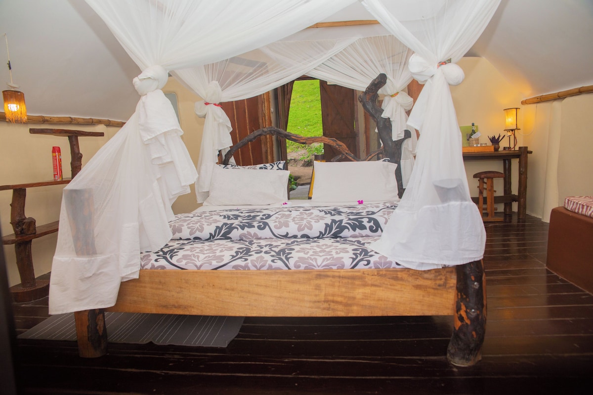 A bed with a canopy, a wooden headboard, and a patterned bedspread.