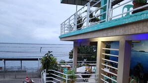A two-story building with a balcony overlooking a body of water.