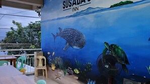 A restaurant with a mural of an underwater scene, a wooden table, and a water dispenser.