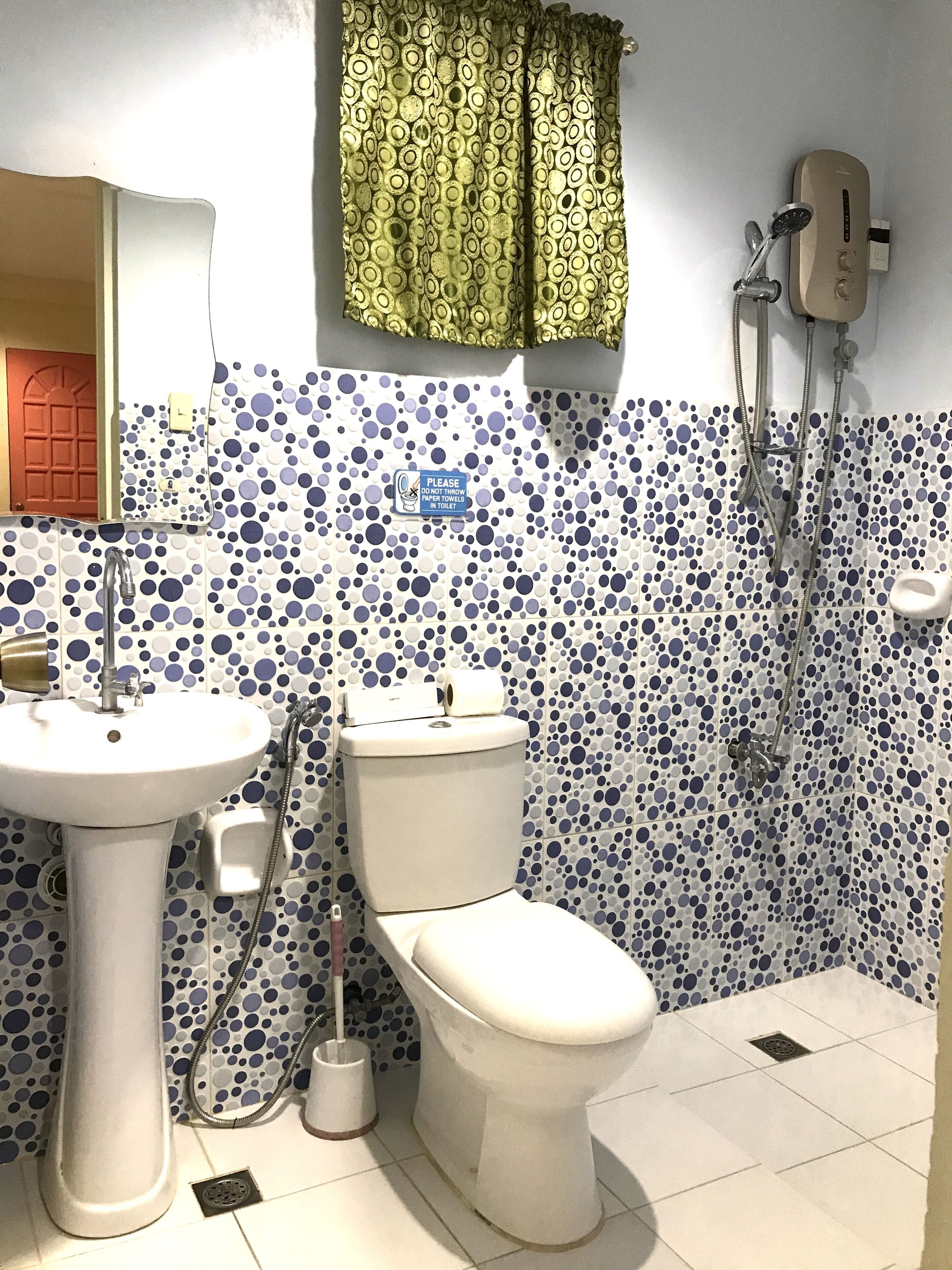 Une salle de bain avec des toilettes, un lavabo et une douche.