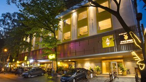 A hotel with a modern facade, multiple windows, and a well-lit entrance. - Fountain Tree by TGI (Bengaluru)